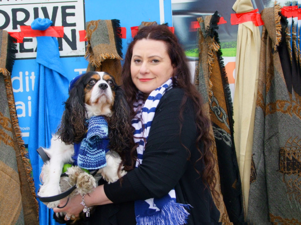 Josie Candito holds her rescue-pup, Charlie in front of the shop. 