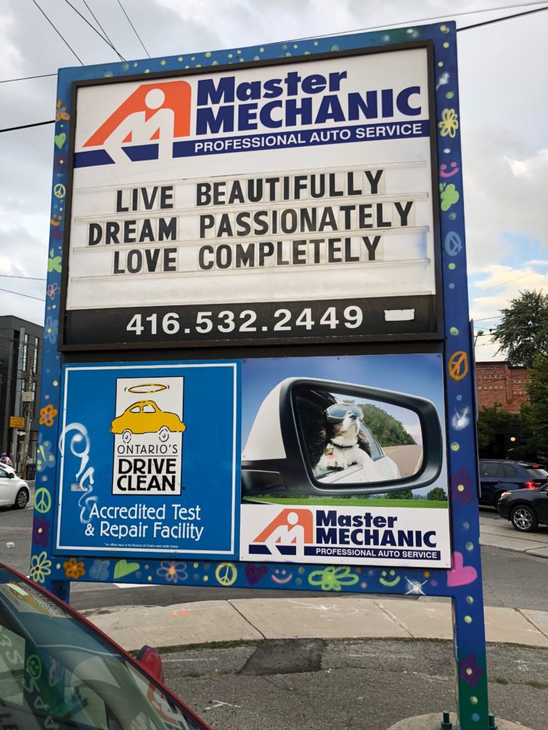 The store sign at Master Mechanic High Park with a positive quote: Live beautifully, dream passionately, love completely.