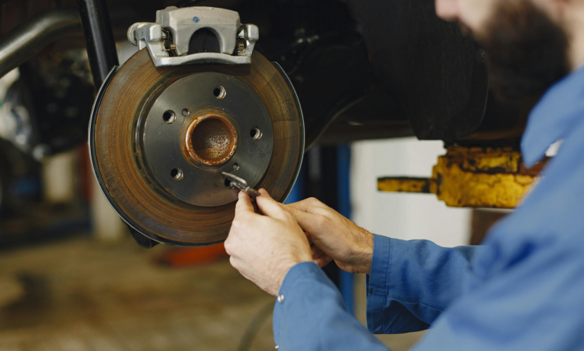 A master mechanic working on a brake disc at an auto repair shop